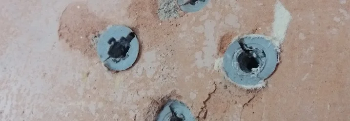 Vier Dübel in einer Wand